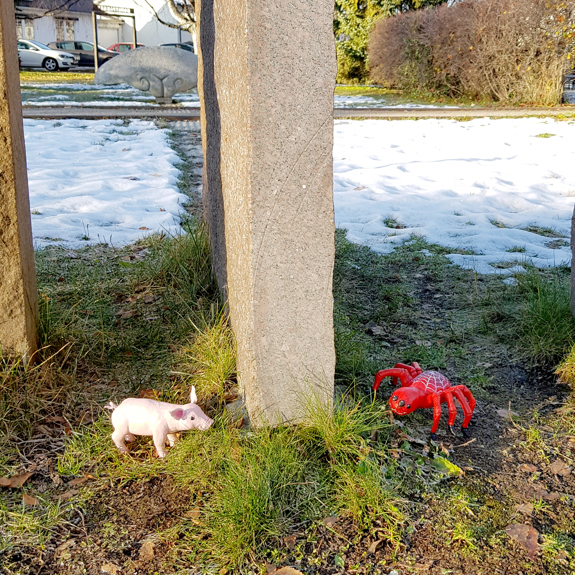 Grisen och Spindeln vid stenpelare.
