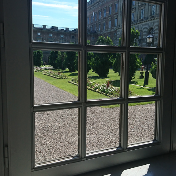 Ett fönster med en trädgård utanför.