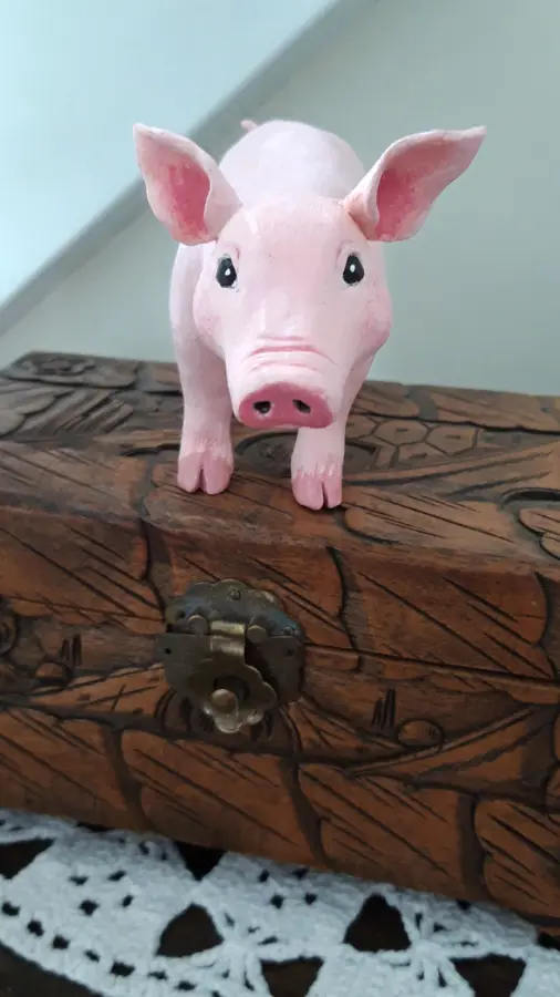 Grisen som står på en skattkista.